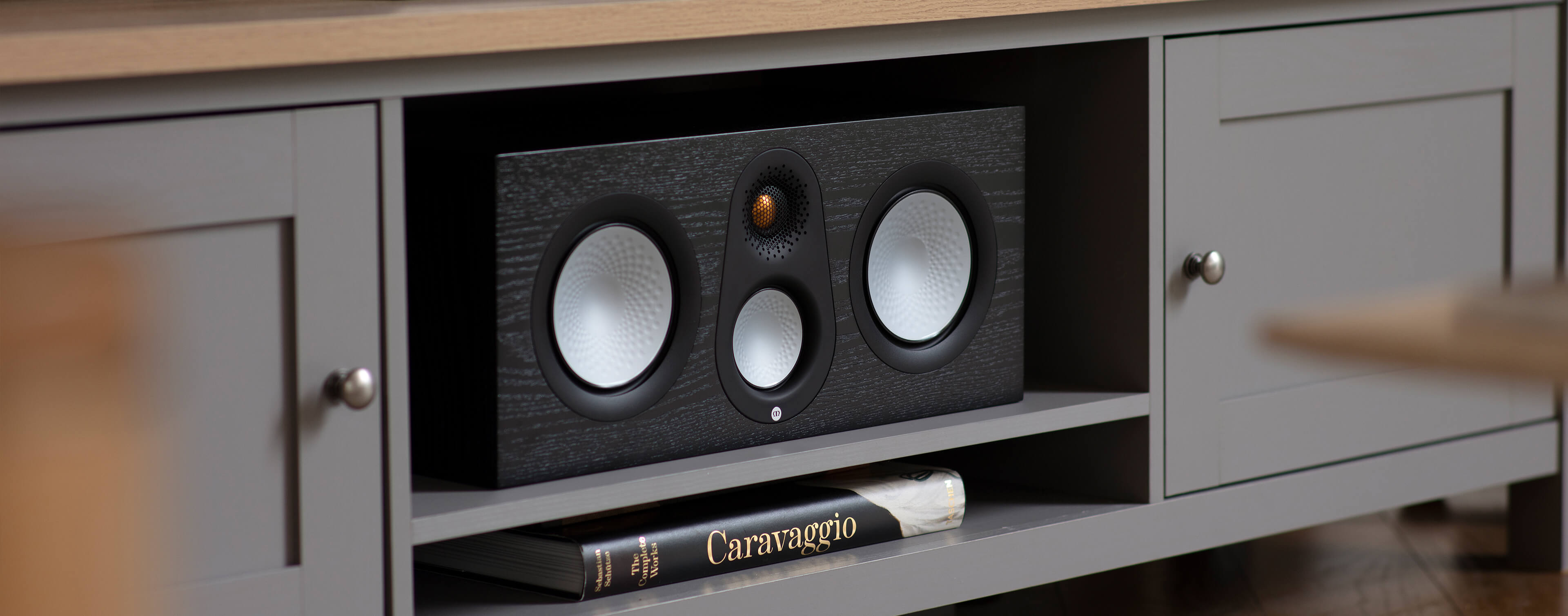 Lifestyle shot of Monitor Audio's Silver C250 7G, in a black oak finish.